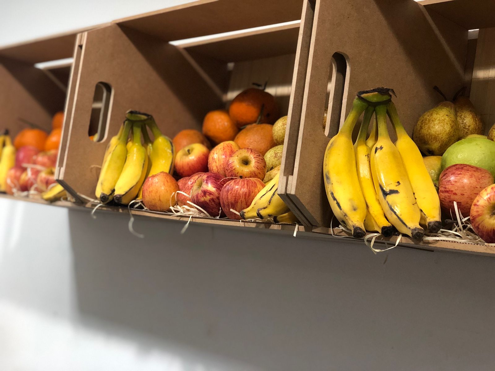 Três caixotes com diversas frutas para uso da empresa Redeplan