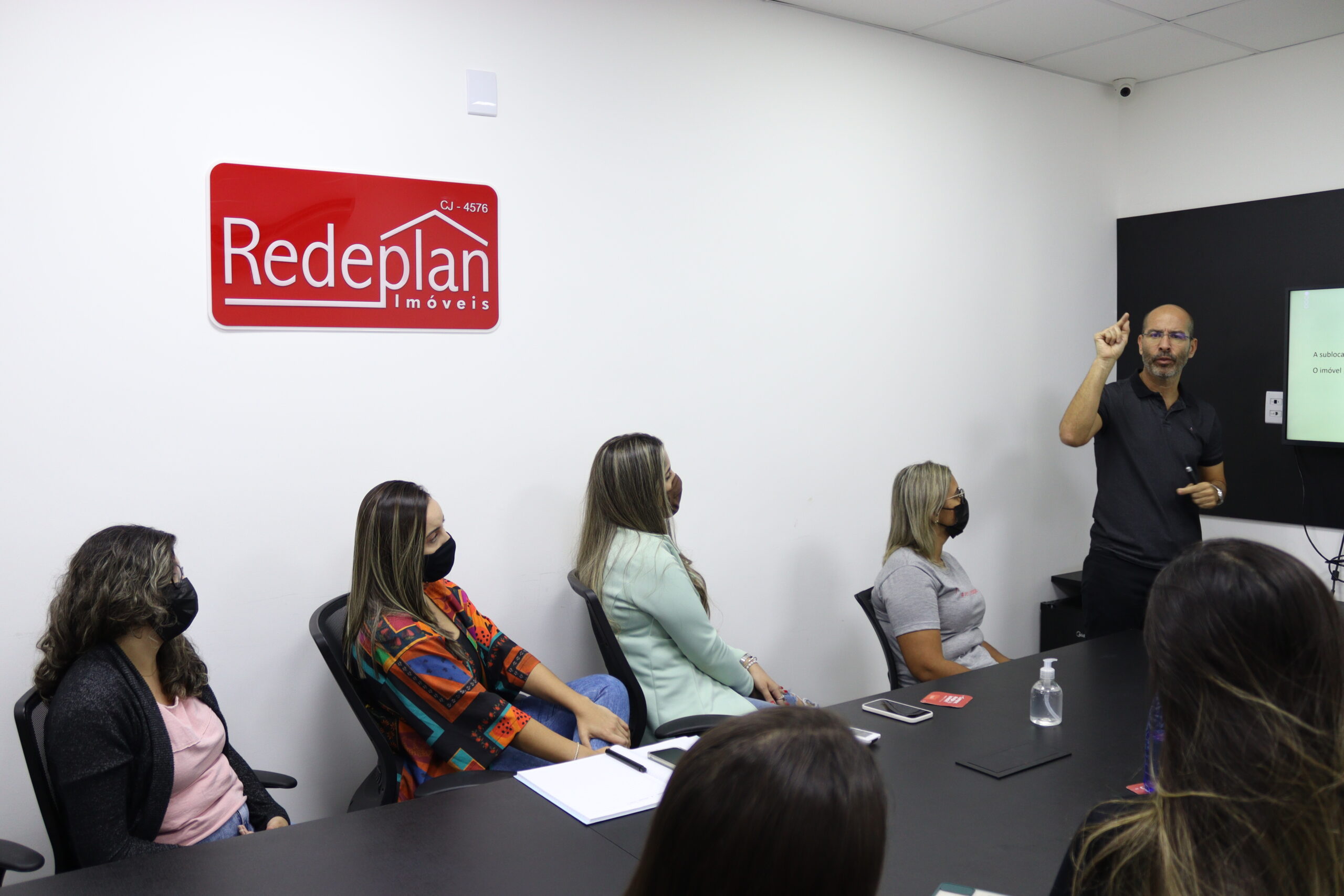 Diretor da Redeplan, José Francisco, ministrando o treinamento para a equipe de locação, administrativo e comercial na sala de reuniões da empresa.
